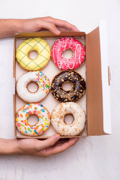 Colored donuts with glaze. Assorted doughnuts with different fillings in the box  - Foto, Imagen
