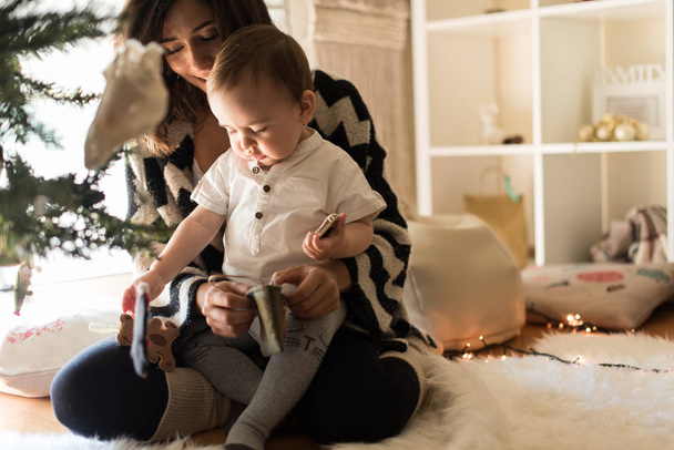 Mom and baby decorating the Christmas tree. - Foto, immagini