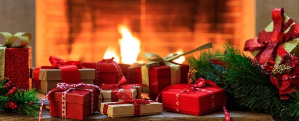 Christmas gifts on burning fireplace background - Foto, Imagen