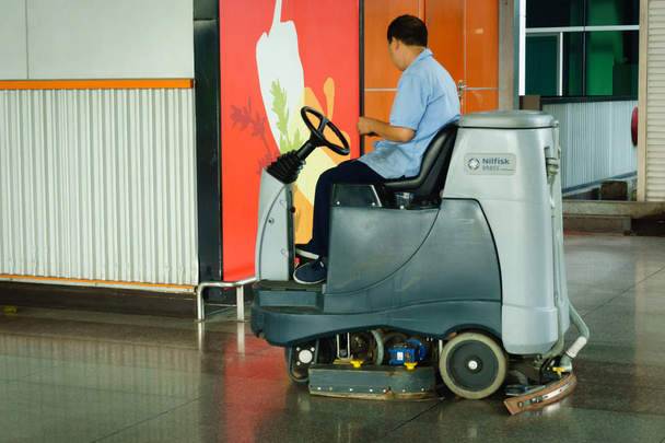  εργάτης καθαρισμού πάτωμα κατάστημα με μηχάνημα - Φωτογραφία, εικόνα