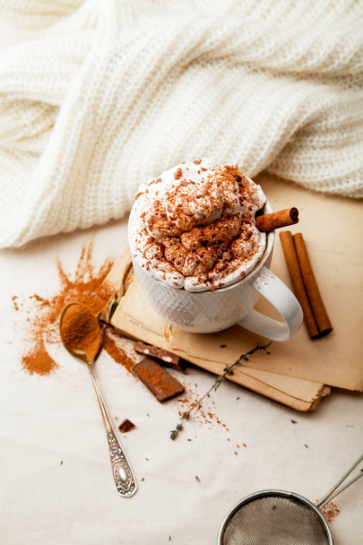Cup of cocoa with cinnamon, whipped cream and chocolate. Textile background. Scandinavian winter concept. Vertical composition. - Fotografie, Obrázek