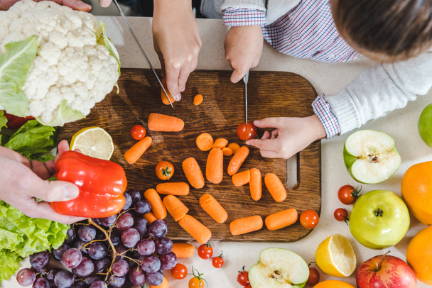 hands slicing vegetables on chopping board - Foto, imagen