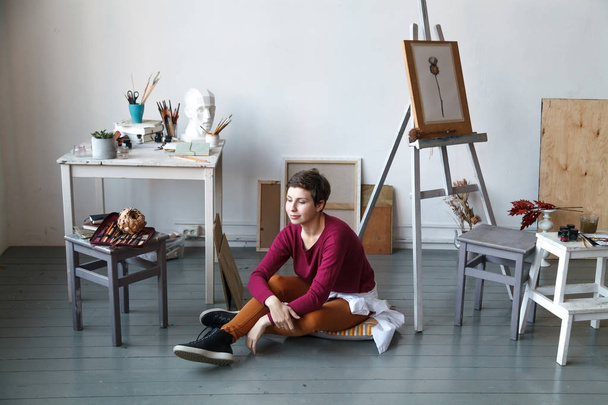 Female artist in her spacious white studio working with watercolor painting.  Natural lighting. Disclosure of creativity concept. Horizontal composition with copy space. - Fotografie, Obrázek