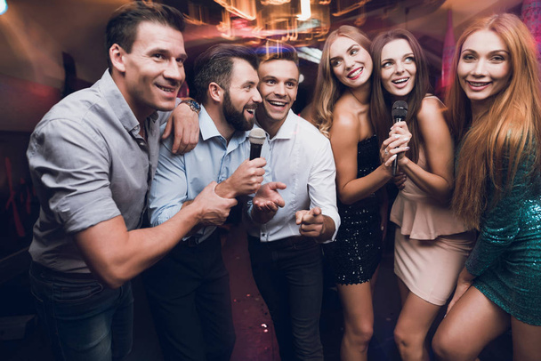 Молоді люди розважаються в нічному клубі. Три чоловіки і три жінки влаштували музичну битву
. - Фото, зображення