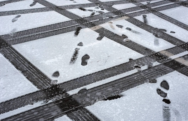 Traces of tires and shoes in the snow. Traces of cars and shoes in the winter season - Photo, Image