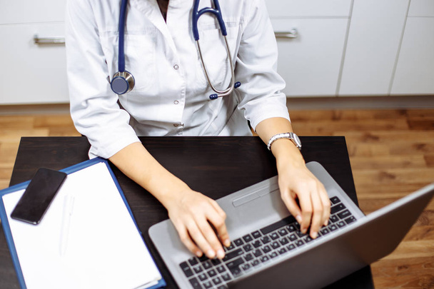Closeup of a female doctor working at laptop - Foto, Imagem