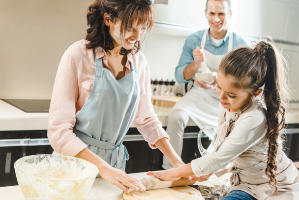happy caucasian family in flour making dough at kitchen - Fotó, kép