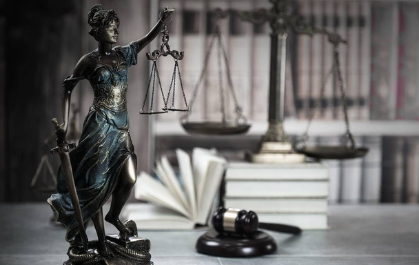 Gesetzeskonzept - offenes Gesetzbuch mit einem hölzernen Richtergabel auf dem Tisch in einem Gerichtssaal oder einer Strafverfolgungsbehörde auf blauem Hintergrund. Kopierraum für Text - Foto, Bild