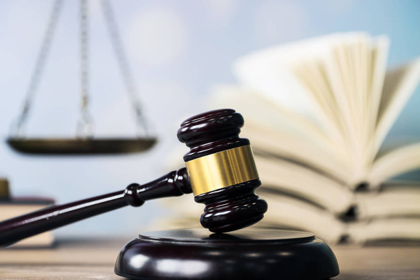 Concepto de ley: libro de leyes abierto con un mazo de jueces de madera sobre la mesa en una sala de tribunal o en una oficina de aplicación de la ley sobre fondo azul. Copiar espacio para texto
 - Foto, imagen