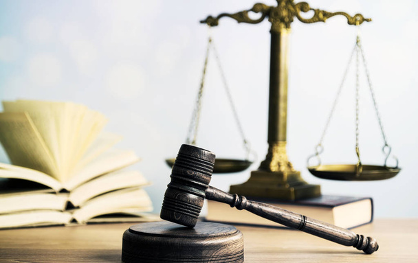Concepto de ley: libro de leyes abierto con un mazo de jueces de madera sobre la mesa en una sala de tribunal o en una oficina de aplicación de la ley sobre fondo azul. Copiar espacio para texto
 - Foto, imagen