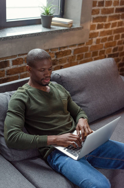 african american man typing on laptop - Foto, afbeelding
