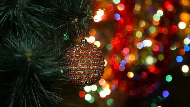 Juguete de Navidad en un árbol de Navidad contra una guirnalda en el desenfoque - Imágenes, Vídeo