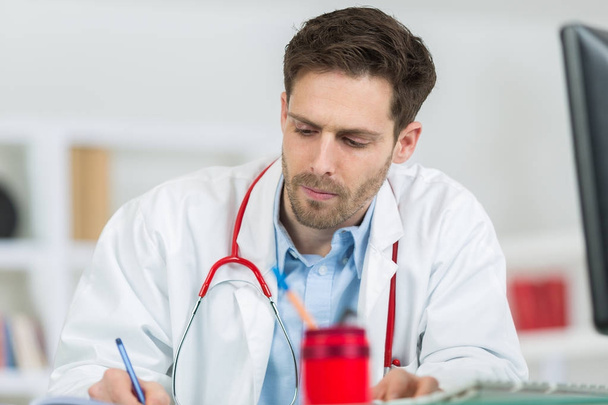 doctor writing prescription in his office - Фото, изображение
