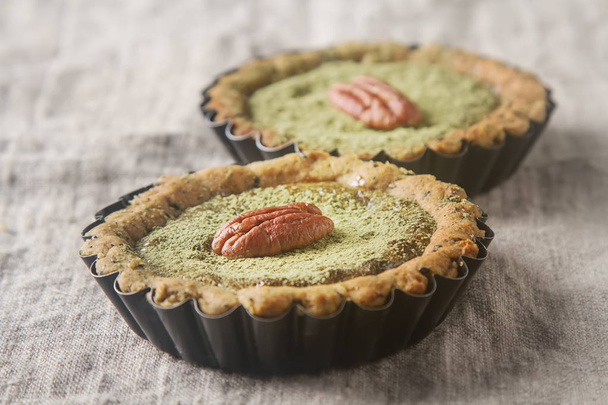 Green tea vegetarian pie match with nuts and mint. Dark backgrou - Fotó, kép