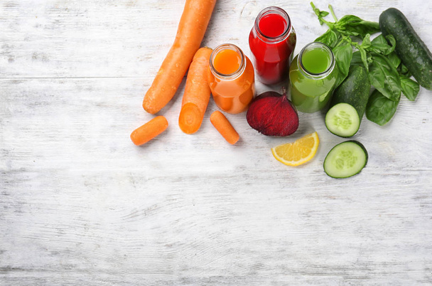 Bottles with various fresh vegetable juices and ingredients  - Фото, зображення