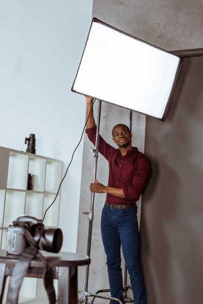 afrikkalainen amerikkalainen valokuvaaja valmistautumassa kuvaukseen studiossa
 - Valokuva, kuva