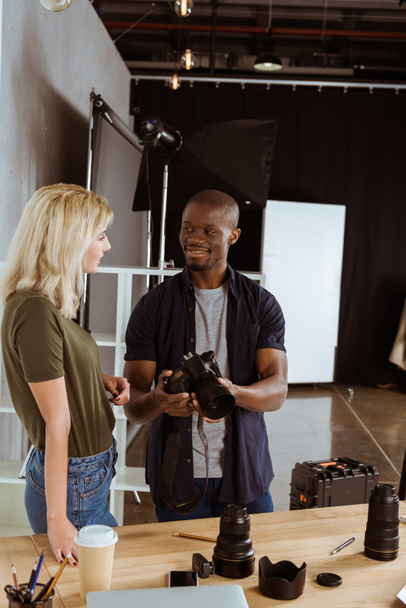 photographes interraciaux parlant de caméras photo sur le lieu de travail en studio
 - Photo, image