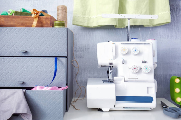 Sewing machine on table in tailor's workshop - Fotografie, Obrázek