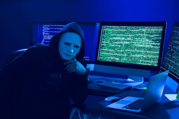 Hacker in mask using computer - Φωτογραφία, εικόνα