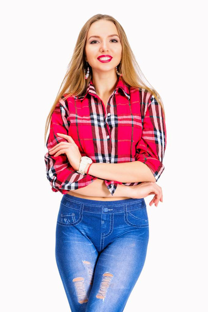 Mujer sexy joven vestida con jeans y camisa a cuadros posando en el estudio
 - Foto, imagen