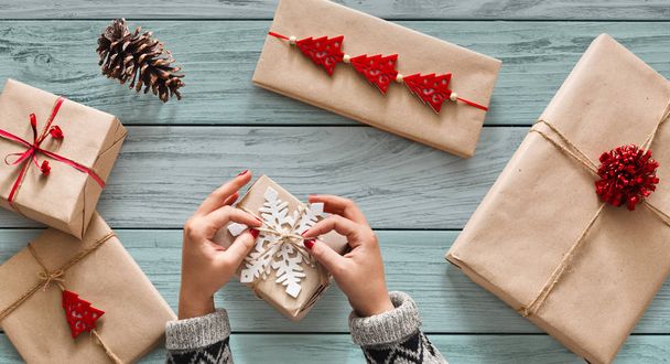 Womans hands wrapping christmas holiday present with craft twin - Photo, Image