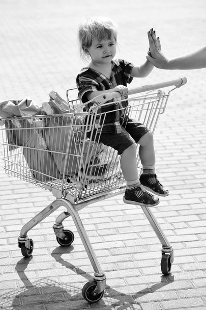Cute boy in shopping trolley - Foto, Imagen