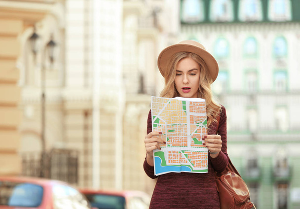 Young female tourist with map on the street - Photo, image