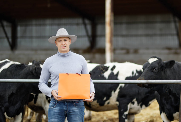 Agriculteur travaillant à la ferme avec des vaches laitières
 - Photo, image