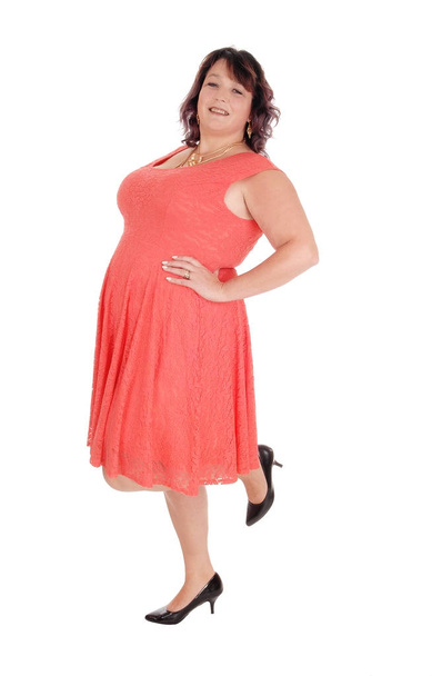 A plus size woman standing in a red dress - Photo, Image