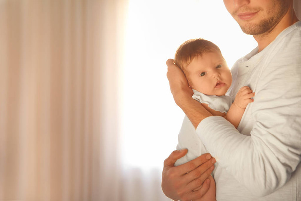 Young father holding baby at home - Foto, Bild