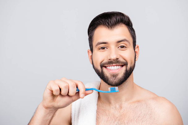 Close up portrait of toothy, attractive man cleaning his white t - Fotó, kép