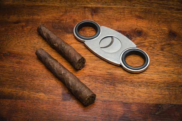Italia, puros italianos (toscani) y un cortador de puros en una mesa de madera
 - Foto, Imagen