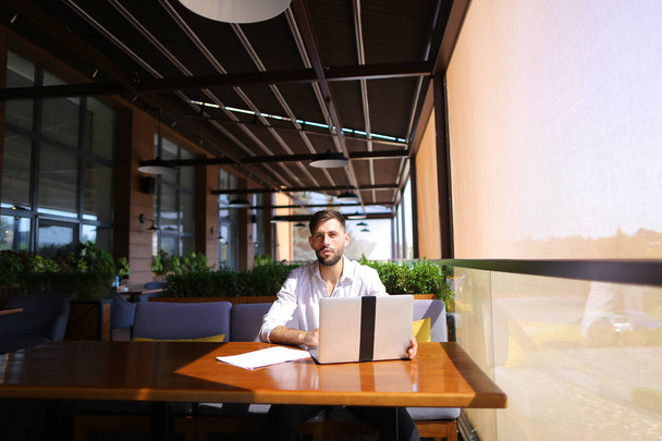Στρατηγός απογραφής που εργάζονται με το laptop στο τραπέζι του καφέ. - Φωτογραφία, εικόνα