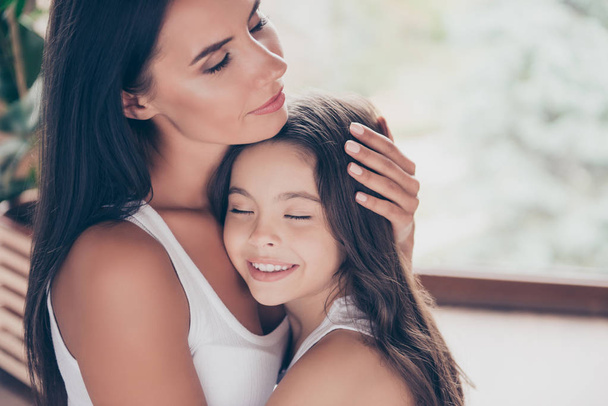 Close up photo of hugging smiling mother and daughter, the mothe - Фото, изображение