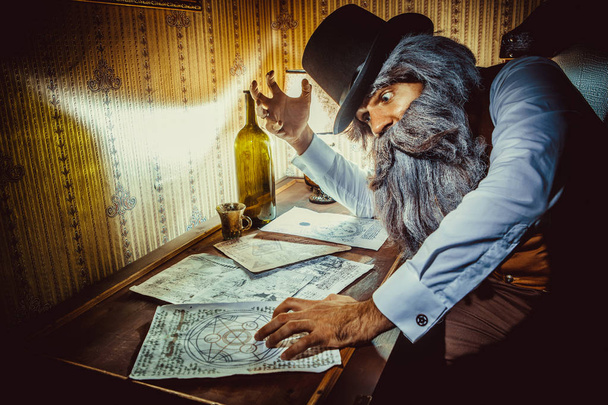Γενειοφόρος άνδρας διαβάζει ένα μυστηριώδες γράμμα στο σκοτεινό δωμάτιο - Φωτογραφία, εικόνα