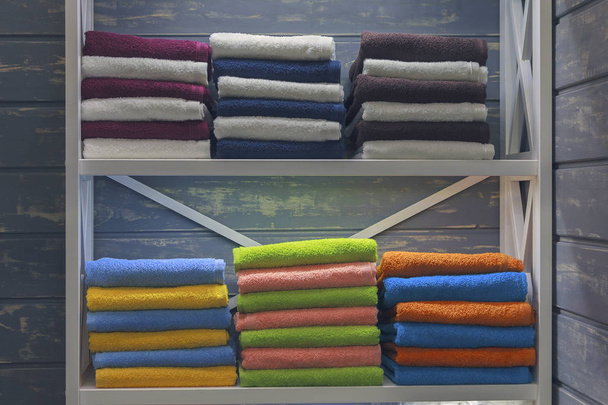 На полке разноцветные полотенца. Продажа
 - Фото, изображение