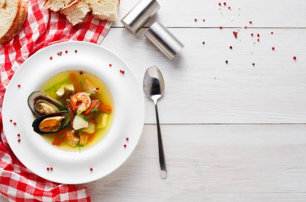 Sopa de mariscos franceses con pescado blanco, camarones y mejillones en plato sobre fondo de madera
 - Foto, Imagen