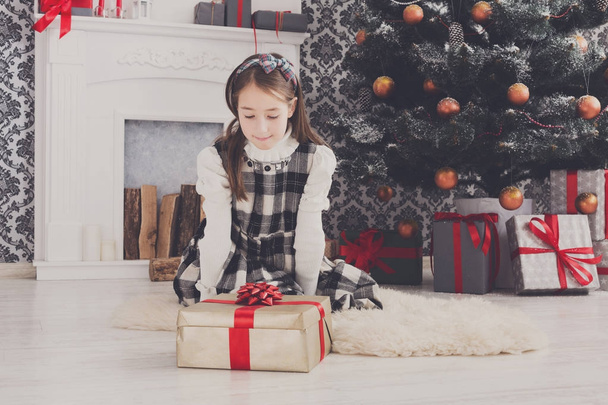 Красивая девушка разворачивает рождественские подарки
 - Фото, изображение