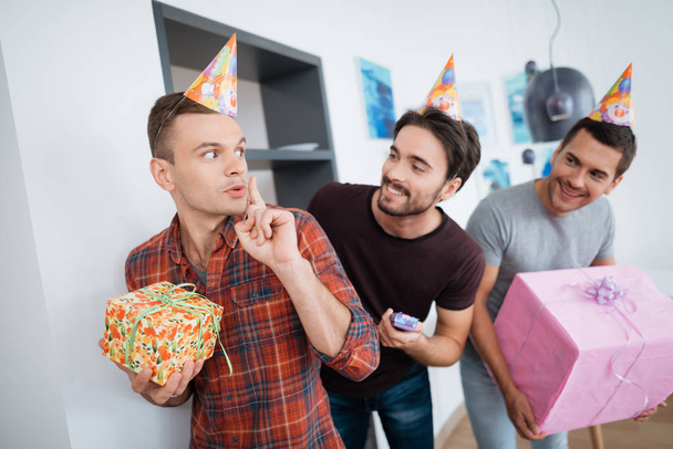 Men in birthday hats are preparing a surprise birthday party. They are preparing to meet the birthday girl. - Photo, Image