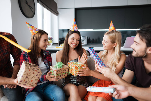 Party in honor of the birthday. Guests give their gifts to the birthday girl. The girl is very happy to receive gifts. - Foto, imagen