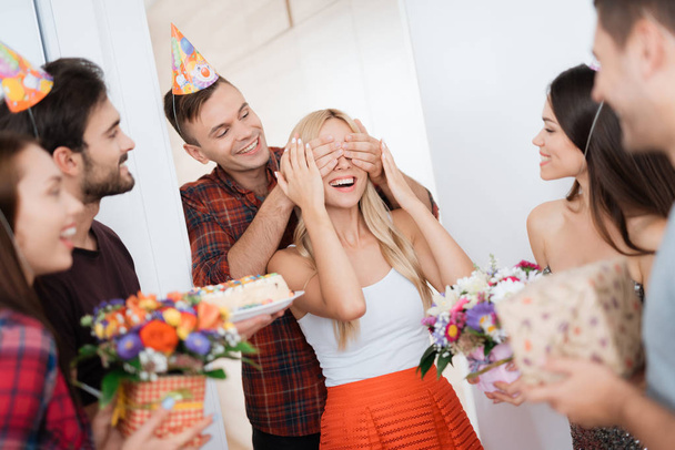 The guy prepared a surprise for the girl's birthday. He closed her eyes by hands. The guy smiles and leads the girl to a surprise. - Foto, Imagem