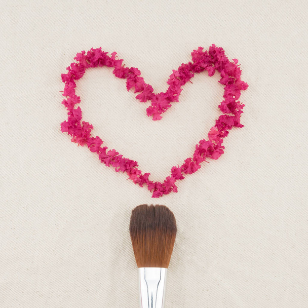 Heart shape pink crape myrtle petals and make up brush from top view - Photo, Image