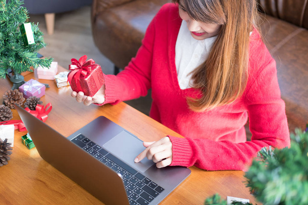 donna usa il computer a casa. ragazza con regalo confezione regalo per Chris
 - Foto, immagini