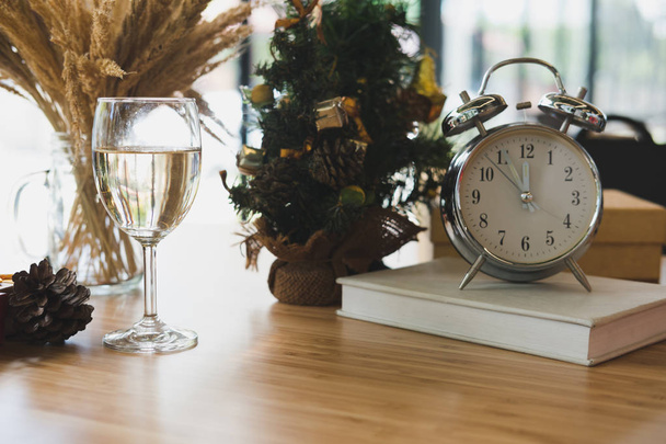 wine glass, clock and book near xmas tree. christmas and new yea - Photo, Image