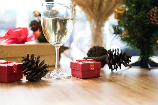 wine glass, gift box and pine cone near xmas tree. christmas and - 写真・画像