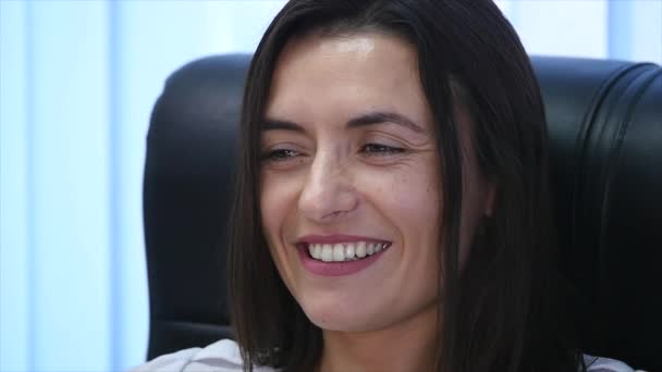 Confident mature businesswoman sitting in an armchair in office. Female manager in office looking at camera and smiling. slow motion - Séquence, vidéo