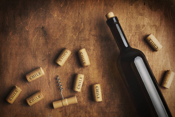 Bouteille de vin avec bouchons de vin autour. L'inscription "Chili" sur les bouchons de vin. Concept de vin chilien
. - Photo, image