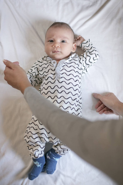 Newborn boy in his bed with mother's hands - Zdjęcie, obraz