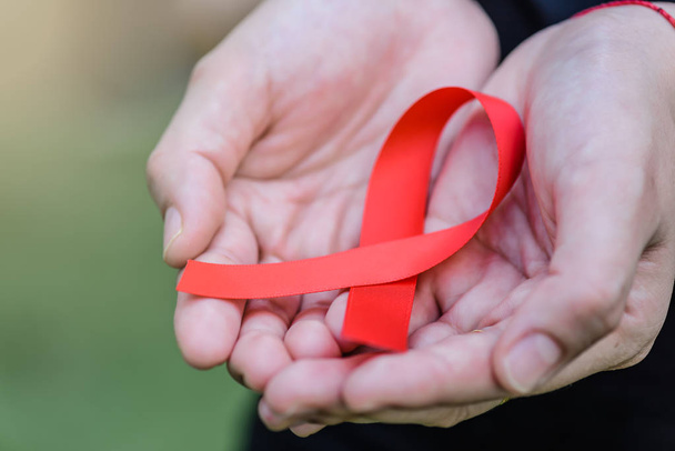  Campagne de sensibilisation au sida. Les mains féminines tenant la conscience rouge du sida
 - Photo, image