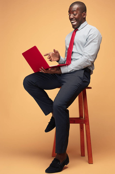 Handsome Afro American man sitting and using a laptop - Zdjęcie, obraz